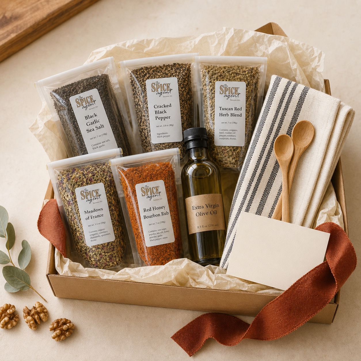 Wedding kitchen starter gift box with Spice Agent pouches, olive oil, a towel, and wooden spoons